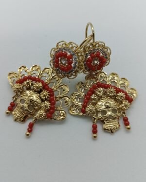 Aretes Mictlán Aretes Mictlán. Laminado de oro, diseño de calavera con filigrana y cuentas rojas.