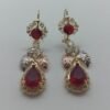 Aretes Gota Carmesi Aretes Gota Carmesí. Laminado de oro, gema roja corte lágrima y detalles de hojas en oro tricolor.
