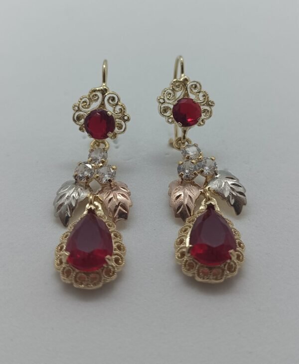 Aretes Gota Carmesi Aretes Gota Carmesí. Laminado de oro, gema roja corte lágrima y detalles de hojas en oro tricolor.