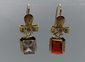 Aretes Moño de Cristal Imperial Aretes Moño de Cristal Imperial. Laminado de oro, moño con gema rectangular (transparente/ámbar).
