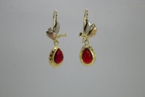 Aretes Gota de Jamaica Aretes Gota de Jamaica. Laminado de oro, gema roja lágrima y hoja en oro tricolor.