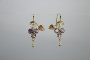 Aretes Hojas de Viñedo Aretes Hojas de Viñedo. Laminado de oro, diseño de racimo de uvas (amatista), perlas y hoja en oro rosa.
