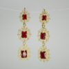 Aretes Candelabro Escarlata Aretes Candelabro Escarlata. Laminado de oro, diseño largo de filigrana con 3 gemas rojas rectangulares.