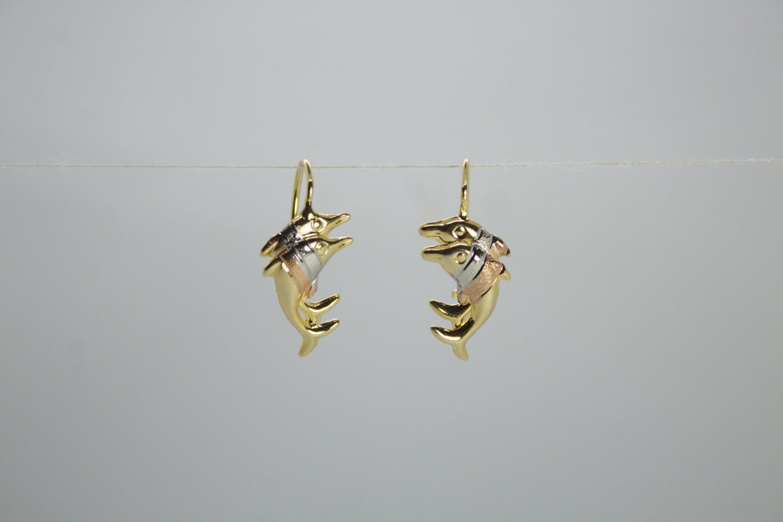 Aretes Danza Acuática Aretes Danza Acuática. Laminado de oro, diseño de dos delfines en oro tricolor.