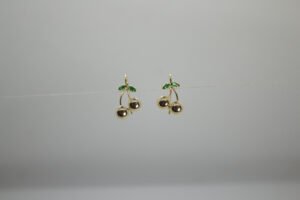 Aretes Frutos de la Pareja. Laminado de oro, diseño de doble fruto/cereza con esmalte verde.
