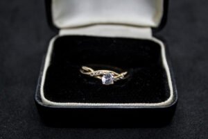 Anillo Artesanal Abrazo de Cristal. Oro 10K (aprox. 2.1 gr). Diseño entrelazado con circonias y cristal central. Producto Artesanal. (Entrega: 5-7 días hábiles)